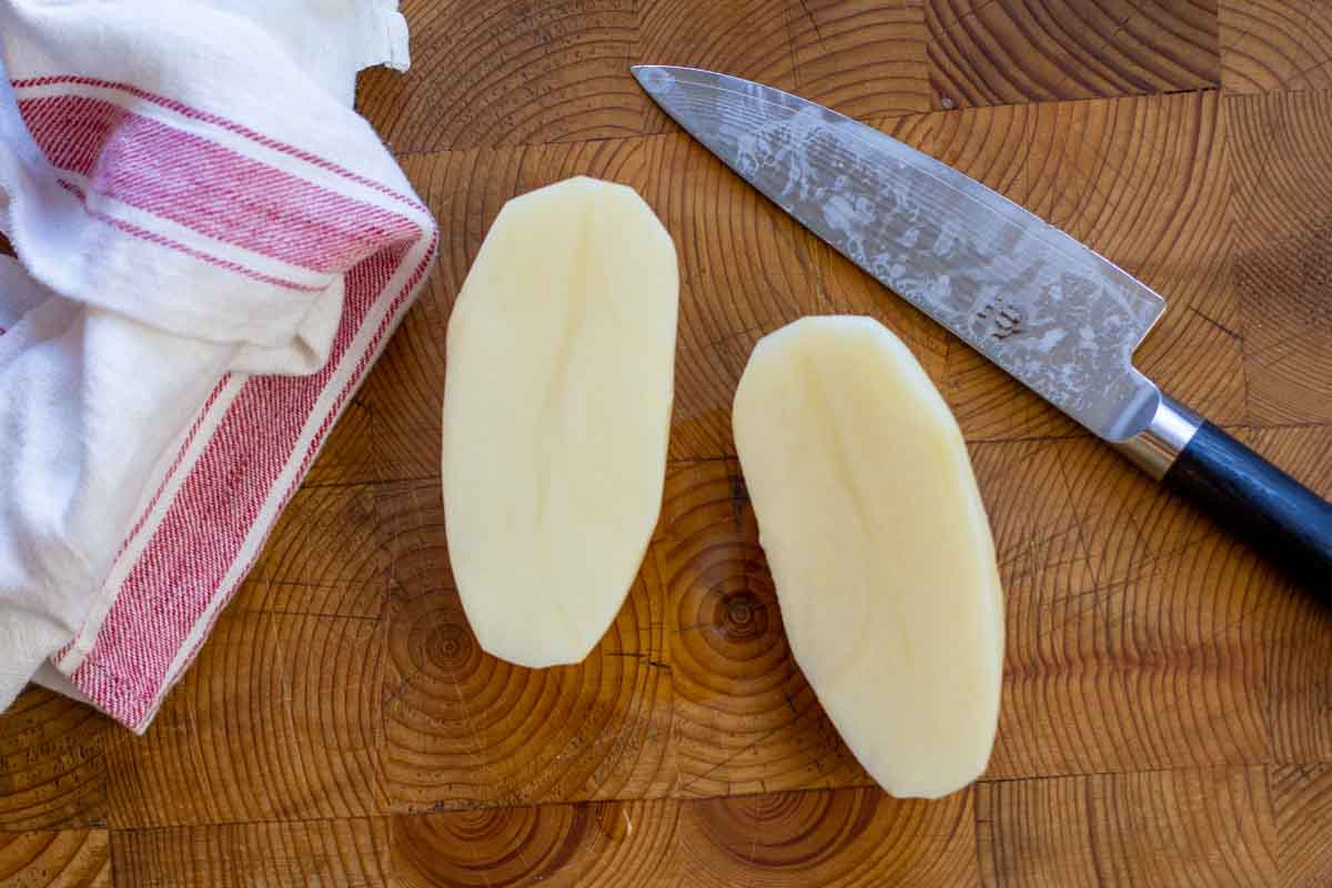 Cutting a russet potato in half to make oven fries.