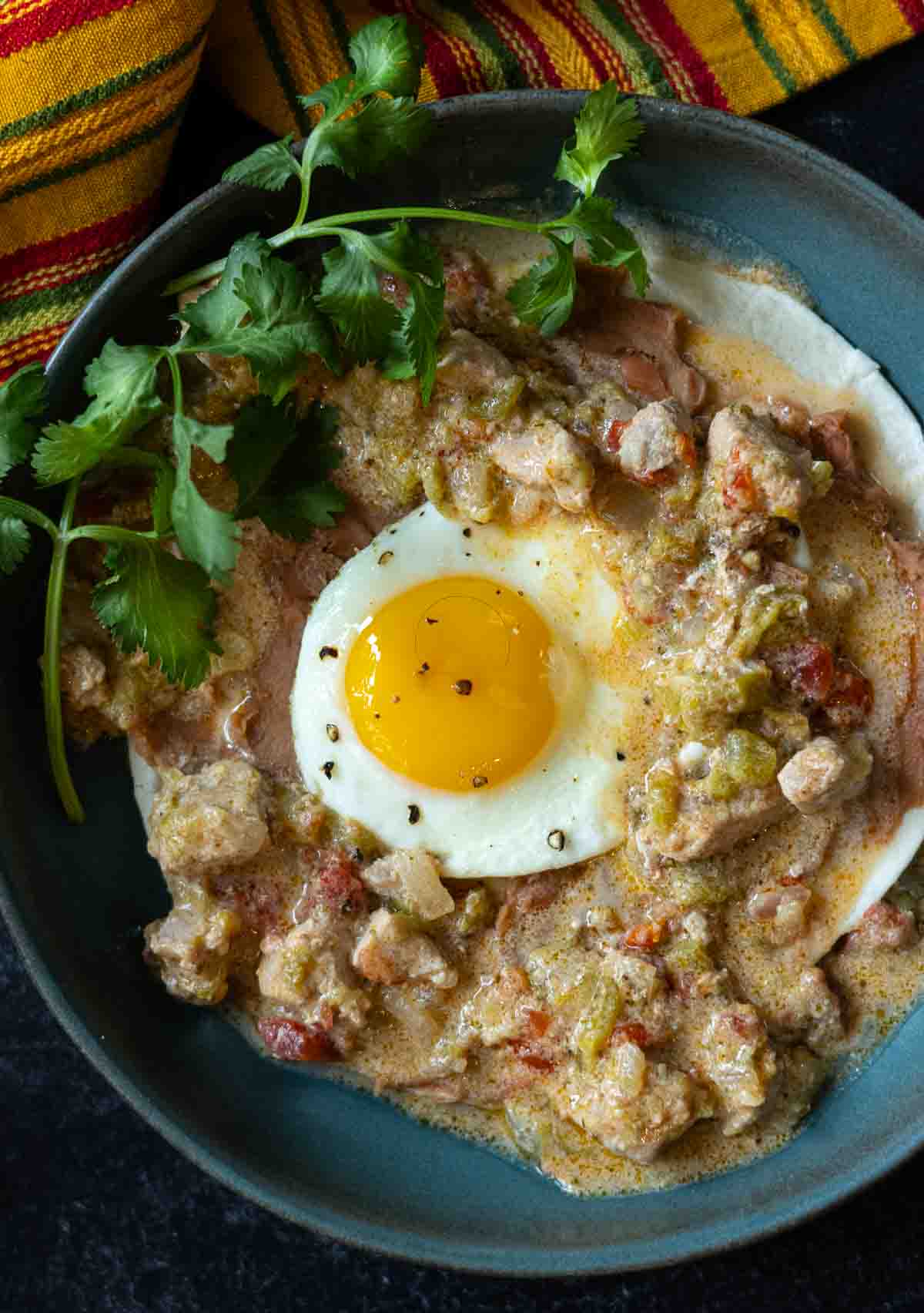 Green chili and eggs served on a plate garnished with cilantro.