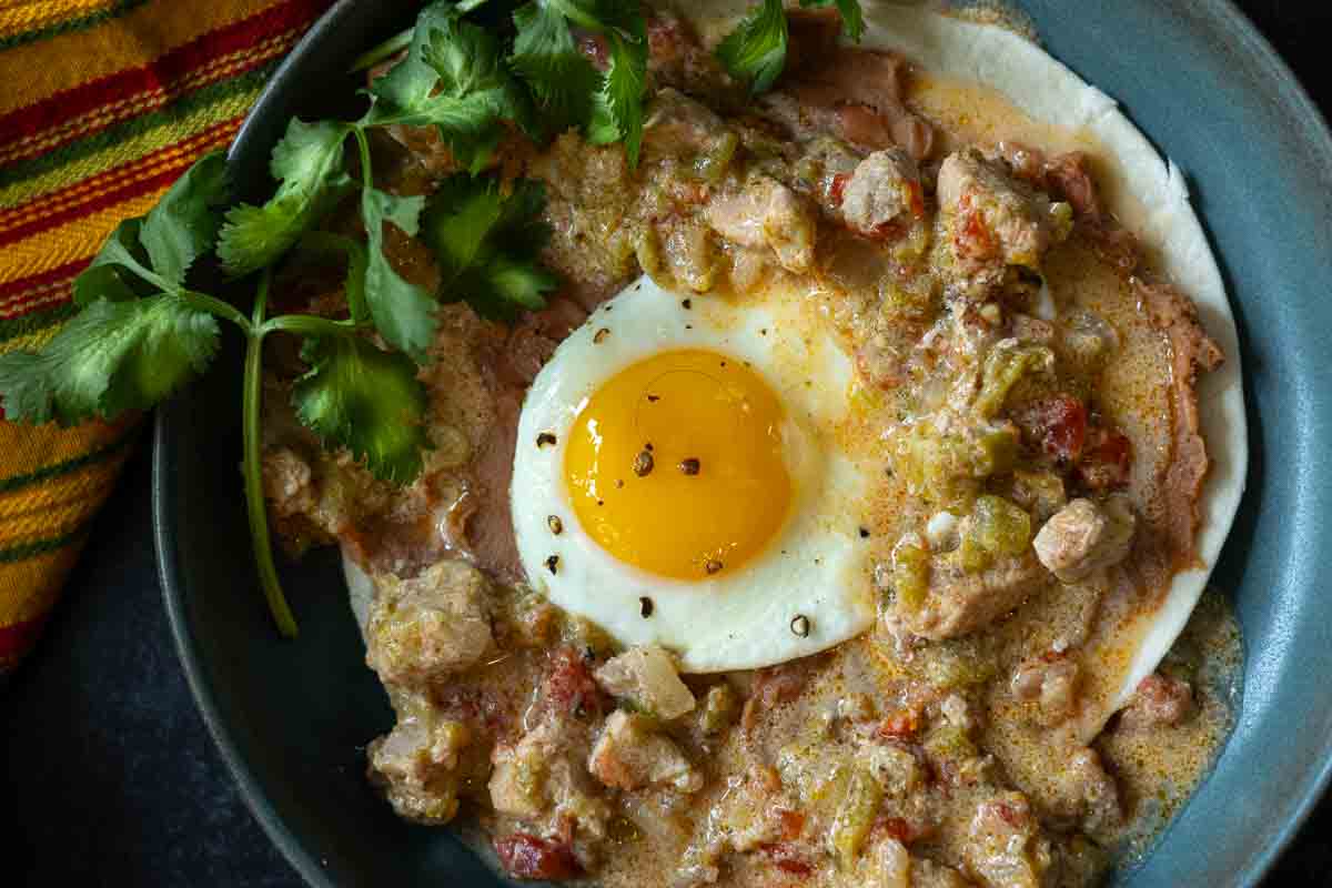 Green chili and eggs served on a flour tortilla with refried beans.