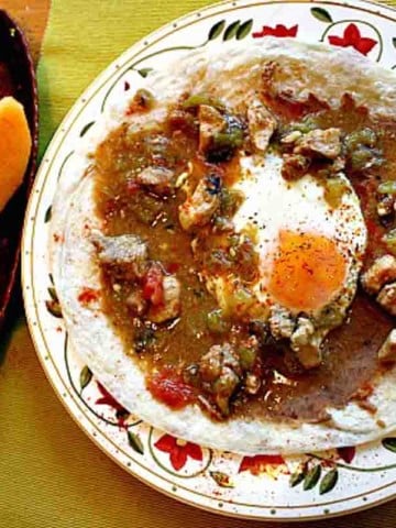 Green Chili and Eggs with refried beans on a flour tortilla.