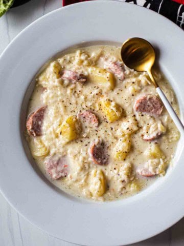 Creamy sauerkraut soup with sausage and potatoes.