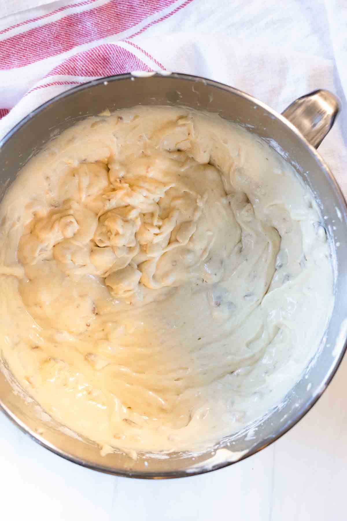 Adding dry ingredients to batter to make old fashioned banana nut bread.