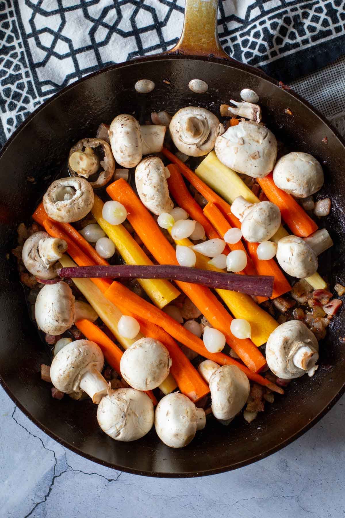 Carrots and mushrooms in a fry pan to make beef stew.