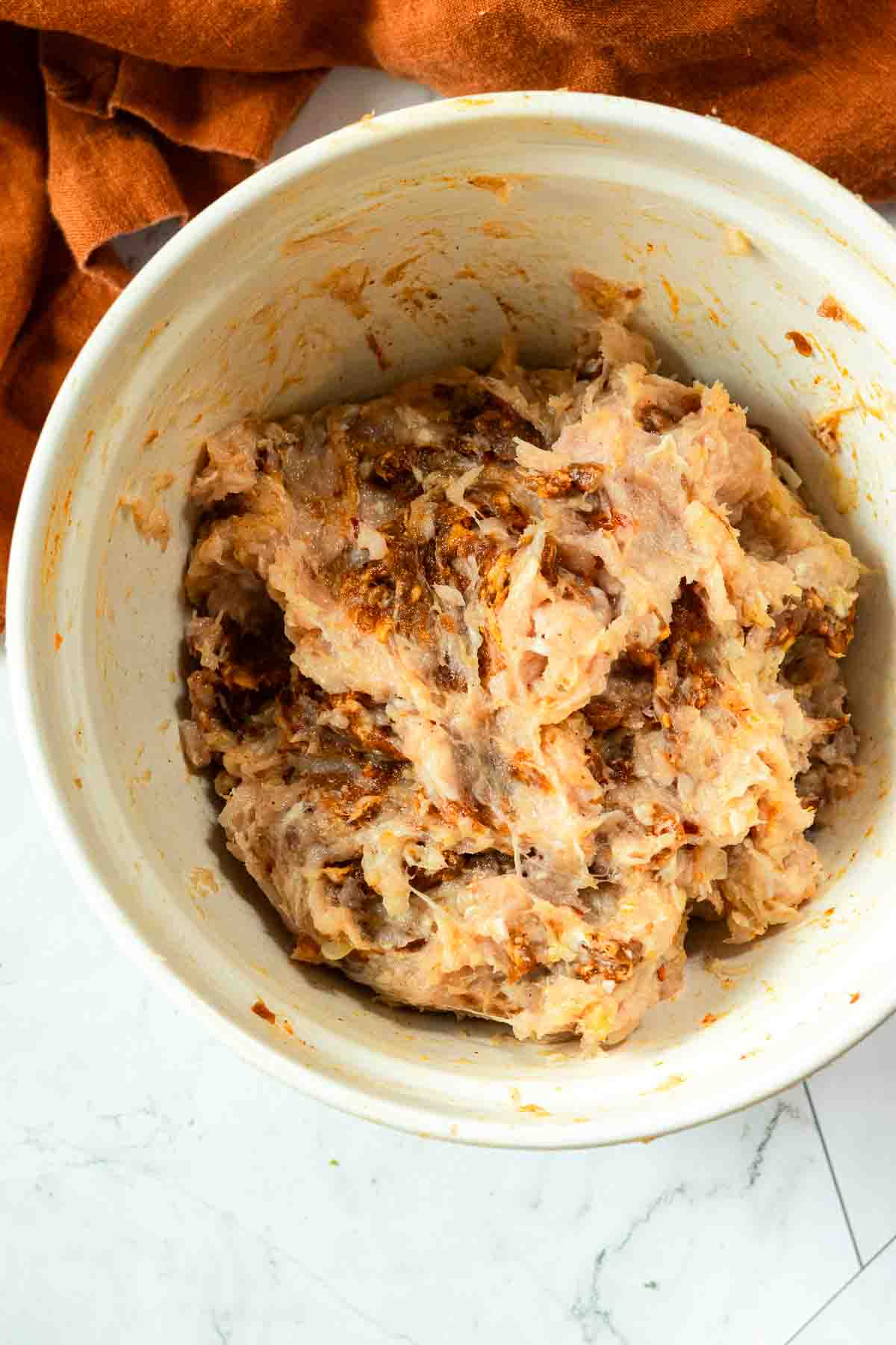 Mixing chorizo with ground chicken to make grilled chicken burgers.