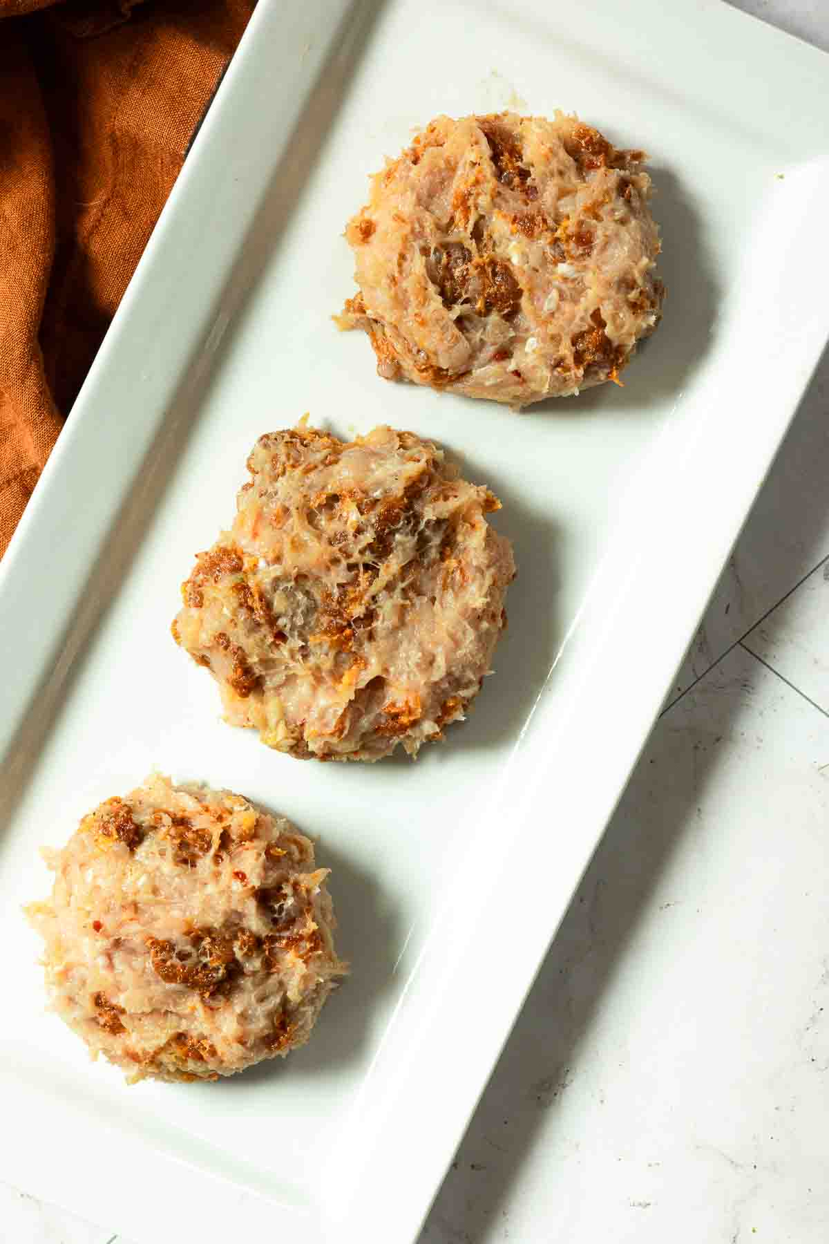 Three chicken patties to make grilled chicken burgers.