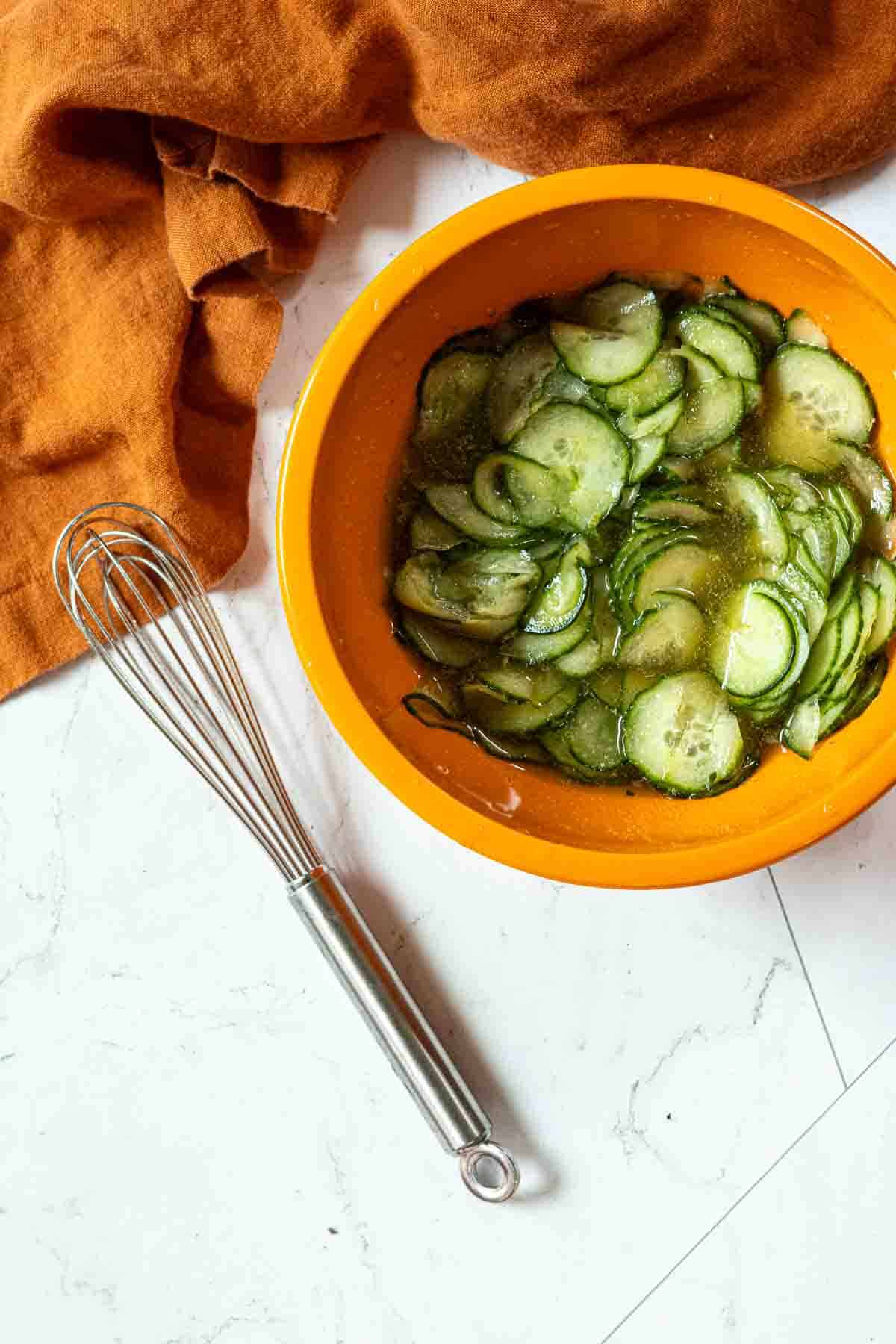 Cucumber slices soaking in liquid to make quick pickles.