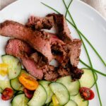 Grilled flank steak marinade with orange and ginger served with asian pickled cucumbers