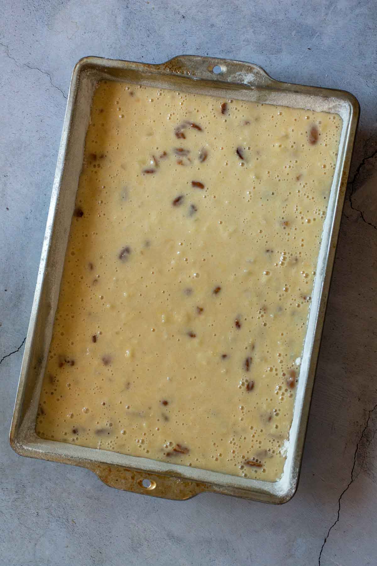 Pineapple cake batter in a rectangular cake pan.