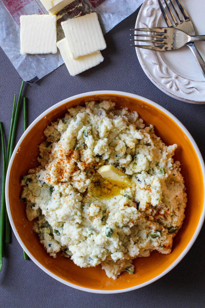 A bowl of mashed potatoes with poblanos and chives sprinkled with New Mexico Chile Powder