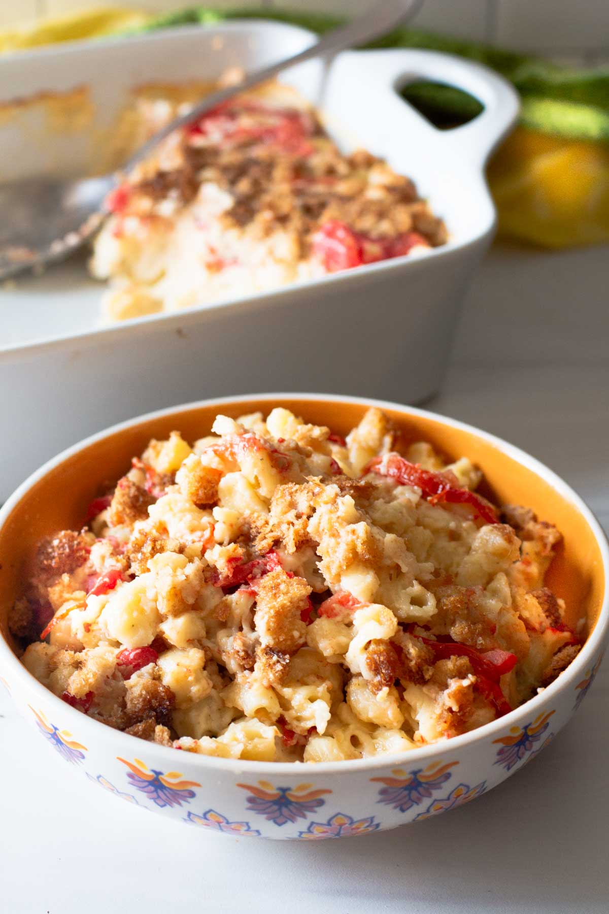 Mac and cheese with tomatoes served in an orange decorative bowl