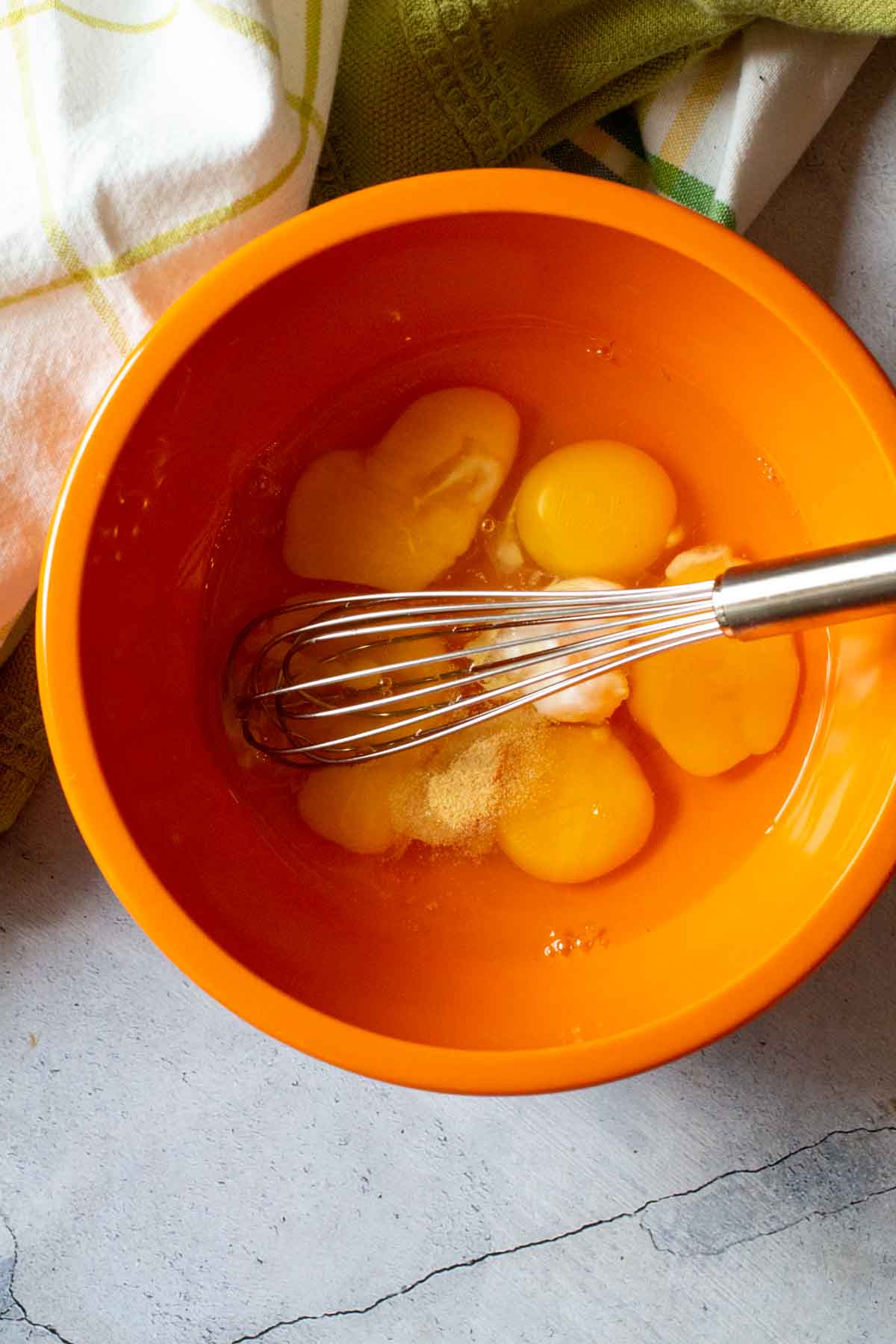 Eggs in a bowl with a whisk to make scrambled eggs.