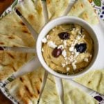 Hummus topped with olives and feta served with grilled pita wedges.