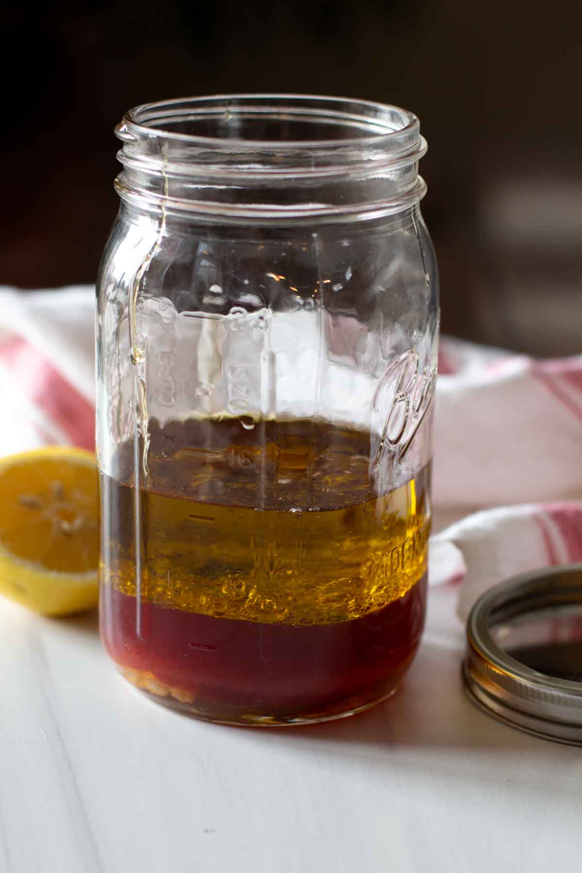 Ingredients to make red wine vinegar dressing is a mason jar.