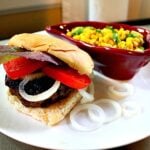 Hatch green chile burger on a plate with Mexican corn