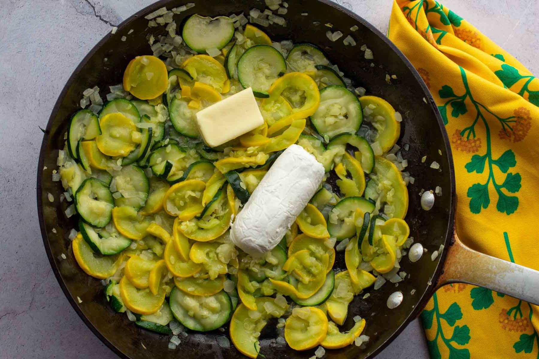 Adding butter and goat cheese for zucchini squash casserole.