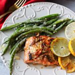 Lemon lime salmon topped with slices of lemon and limes and served with dijon cream green beans.