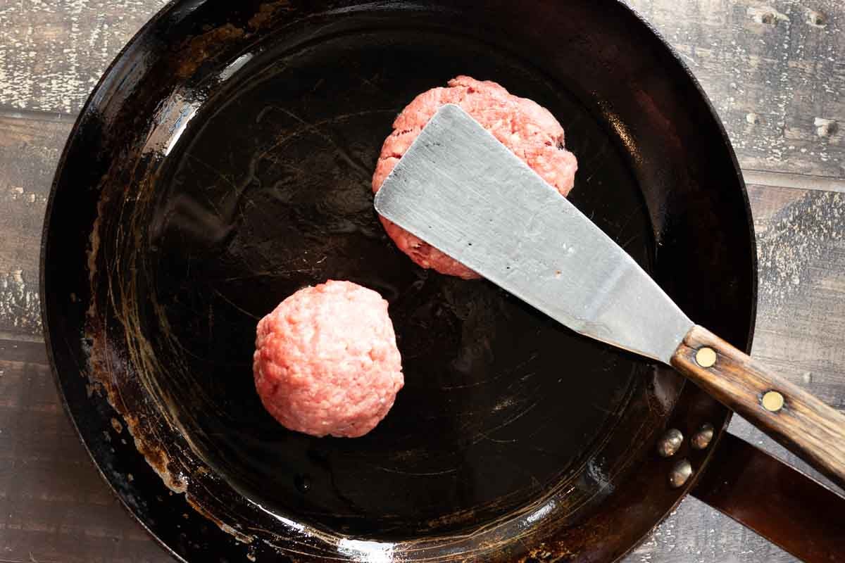 Pan frying hamburger patties.