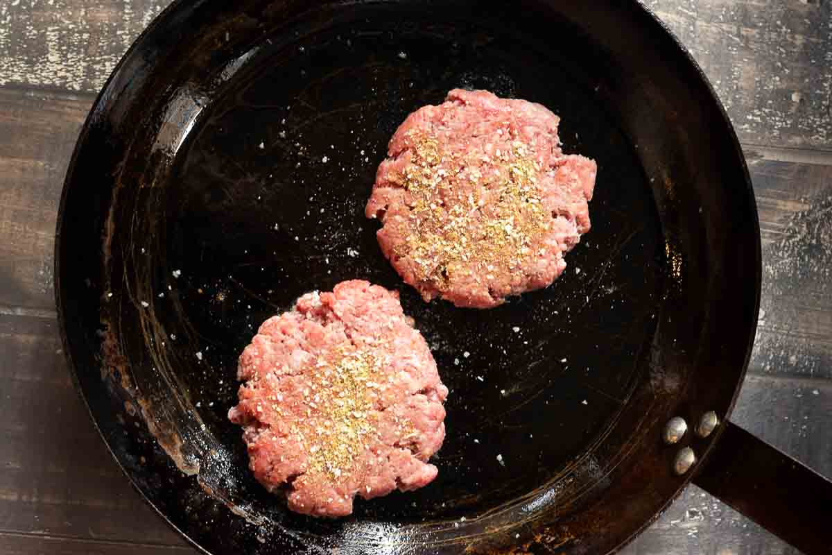 Seasoning pan fried green chile cheeseburgers.