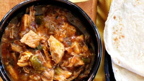 Hatch Green Chili With Pork served with flour tortillas and lime wedges