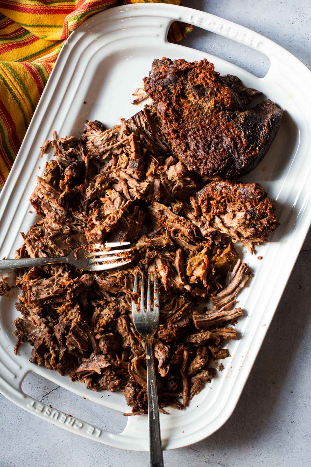 Slow cooker shredded beef barbacoa on a white platter.