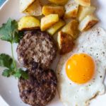 Homemade Turkey Sausage patties with a fried egg and fried potatoes