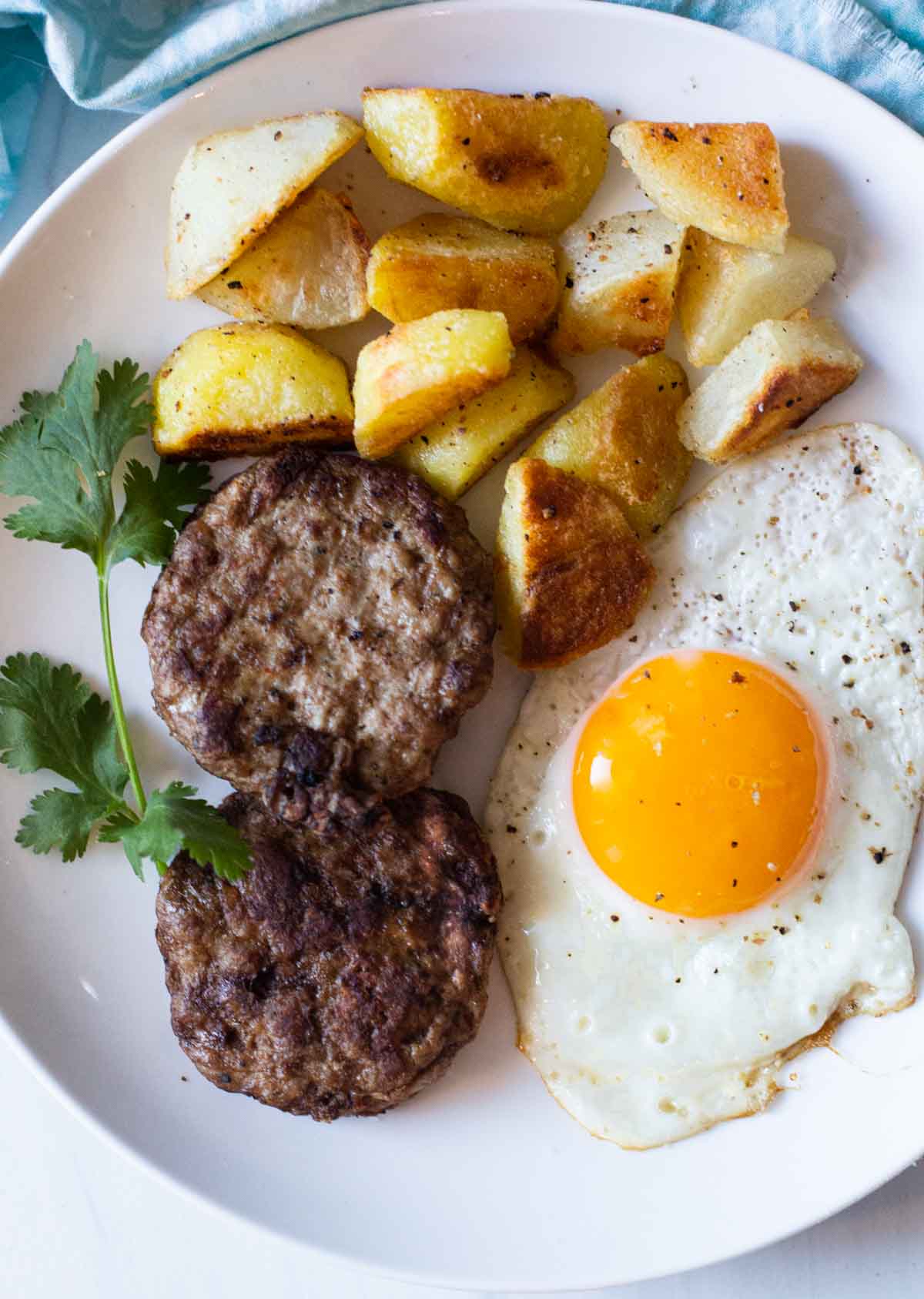 Homemade Turkey Sausage patties with a fried egg and fried potatoes