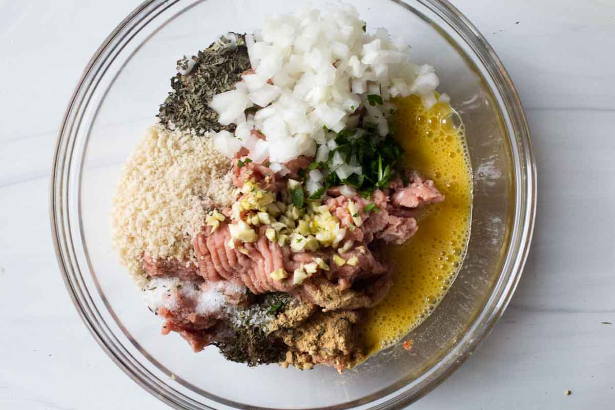 Ingredients to make homemade turkey sausage in a bowl, ready to mix.