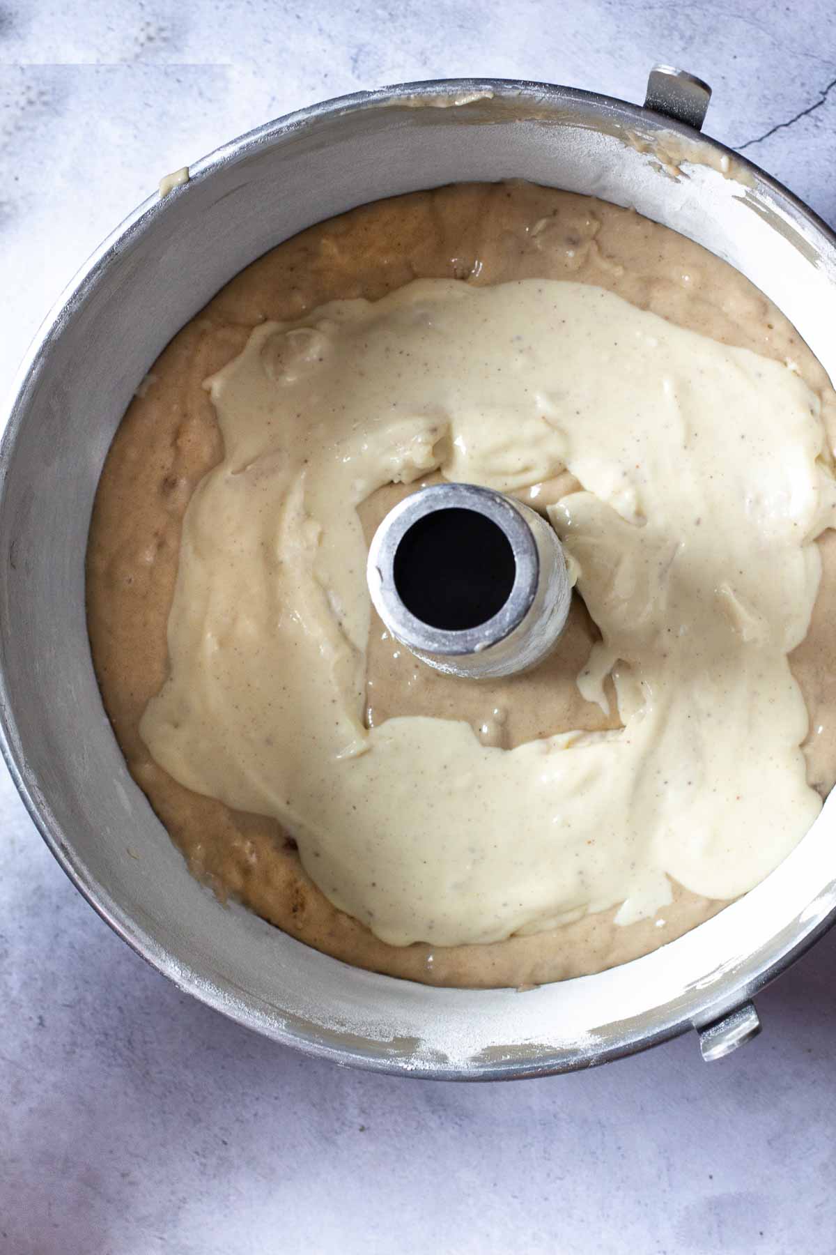 Placing a layer of cream cheese filling in banana coffee cake batter.
