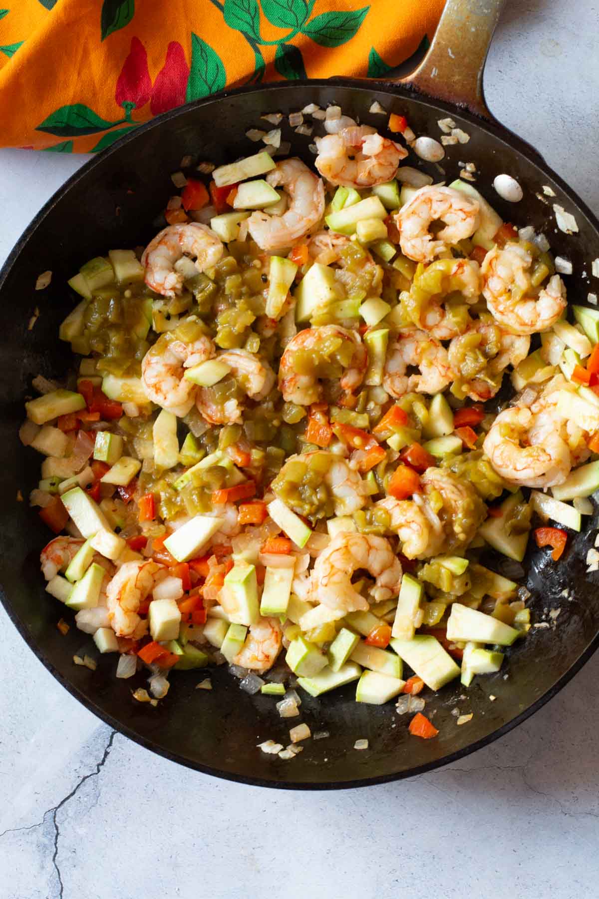 Adding vegetables to make shrimp burritos.