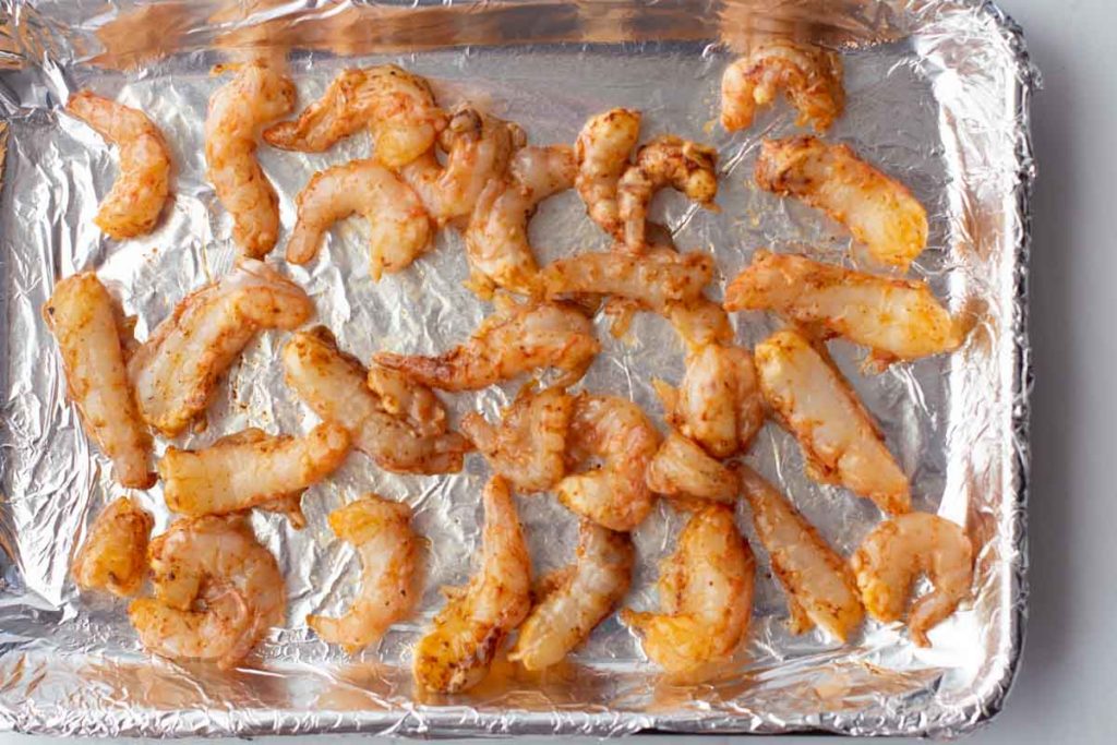Spot prawns tossed with chile powder on a sheet pan lined with foil