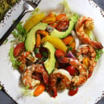 Grilled shrimp salad with avocado, orange wedges, mint and cherry tomatoes