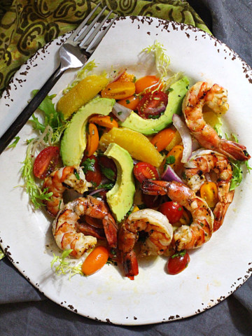 Grilled shrimp salad with avocado, orange wedges, mint and cherry tomatoes