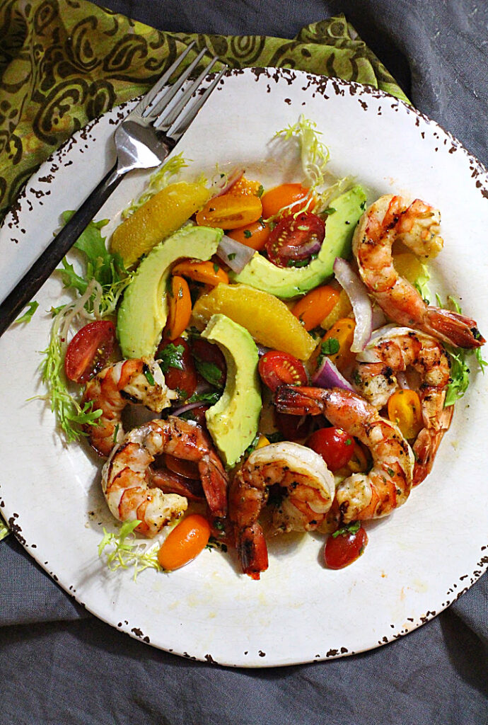 Grilled shrimp salad with avocado, orange wedges, mint and cherry tomatoes