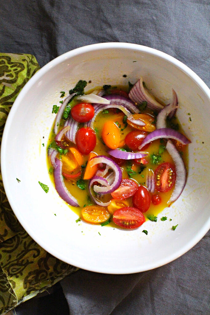 Salad dressing for grilled shrimp salad with red onion, cherry tomatoes, cilantro and olive oil and hot sauce