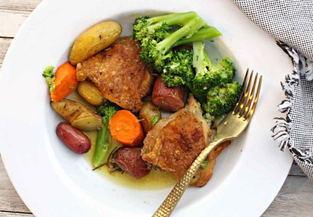 Roasted chicken thighs with rosemary and served with broccoli, carrots and potatoes