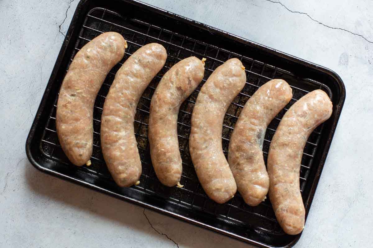 Chicken bratwurst on a sheet pan ready to be roasted.
