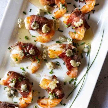 Prosciutto wrapped shrimp drizzled with honey and chopped chives.