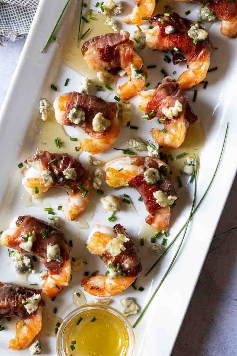 Prosciutto wrapped shrimp drizzled with honey and chopped chives.