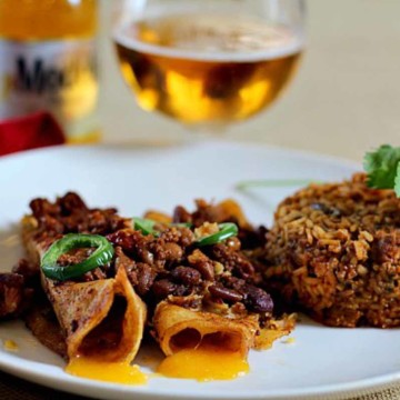 Two chile con carne enchiladas served with Mexican rice.