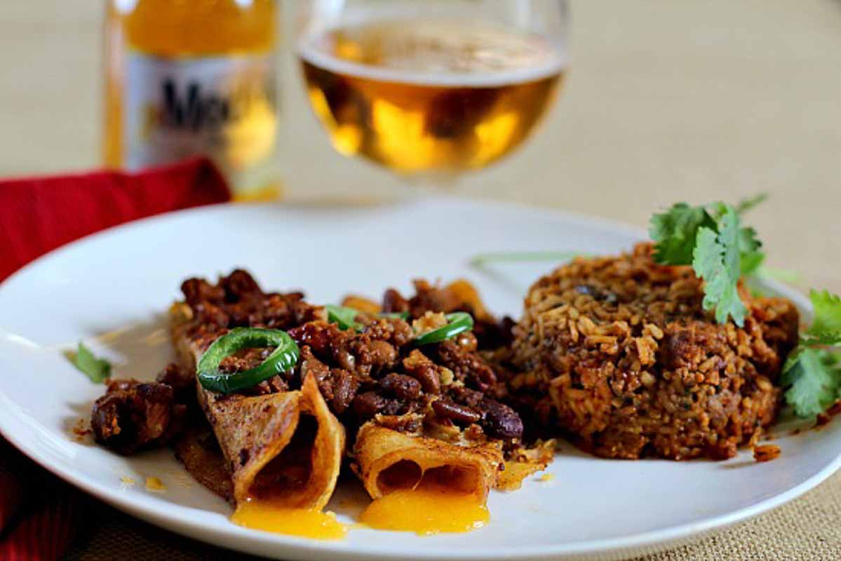 Two chile con carne enchiladas served with Mexican rice.