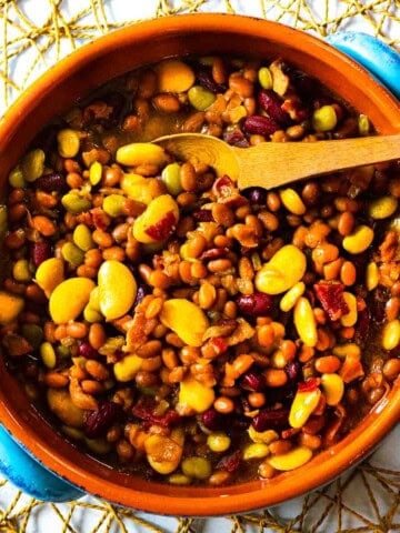 Calico baked beans served in a terra cotta bowl.