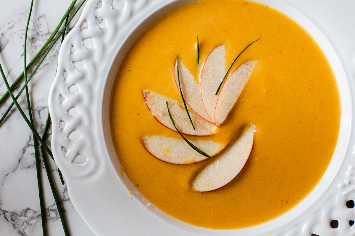 Butternut Squash and Apple Soup garnished with sliced apples and chives