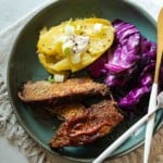 Oven brisket served with baked potato and fried cabbage.