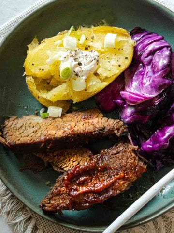 Oven brisket served with baked potato and fried cabbage.