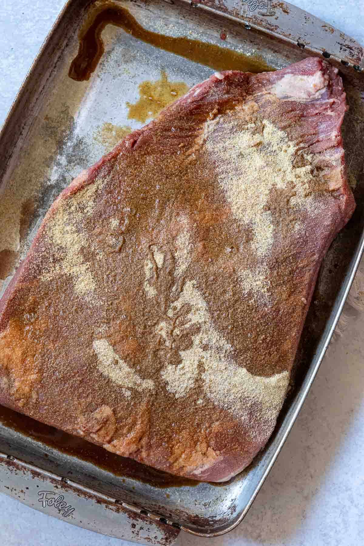 Adding liquid smoke to a brisket for oven baked brisket.