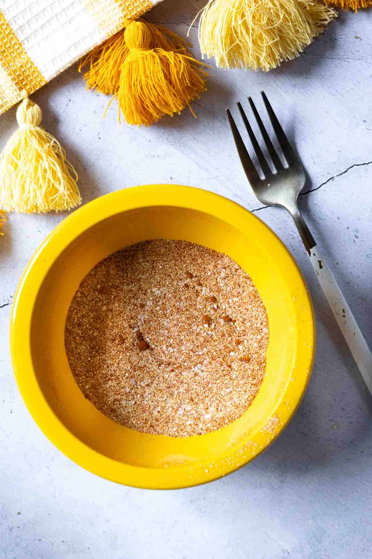 Pulled pork seasoning rub in a small yellow bowl.