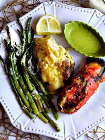 Broiled Lobster Tails served with asparagus and baked potato.