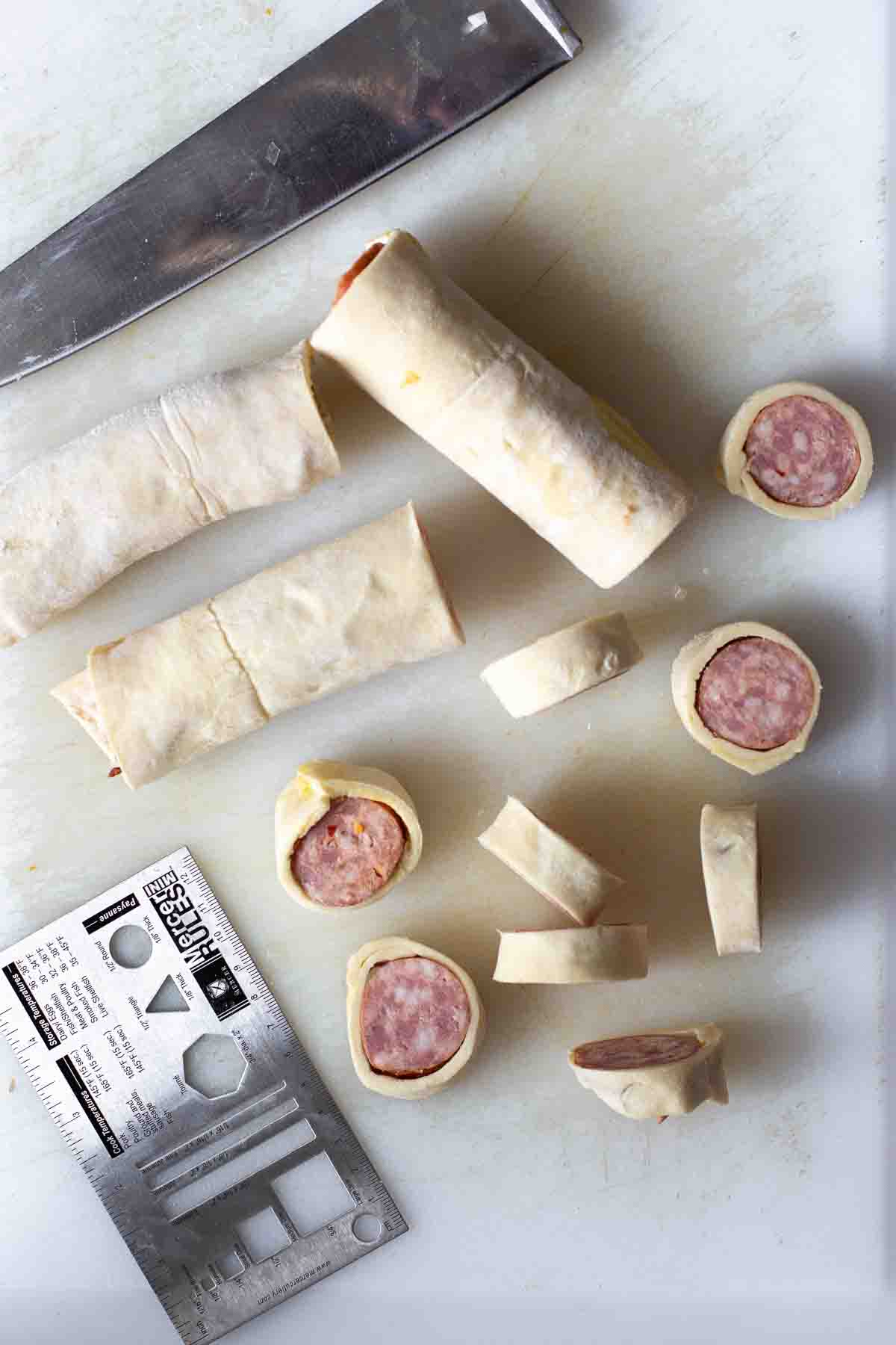 Cutting sausage in a blanket before baking.