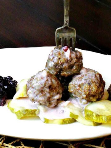 Authentic Swedish Meatballs served with pickles and lingonberries.