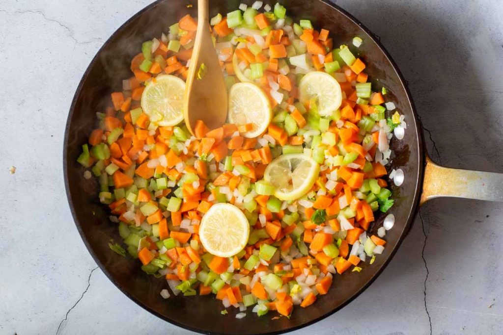 Making mirepoix for chicken soup with chopped carrots, celery and onion.